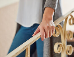A hand grips a banister.